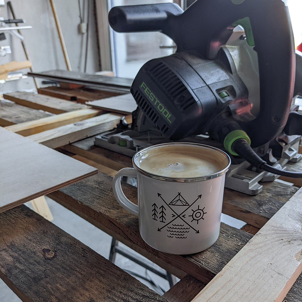 Tauchsäge und ein Kaffee auf einer Sägeunterlage